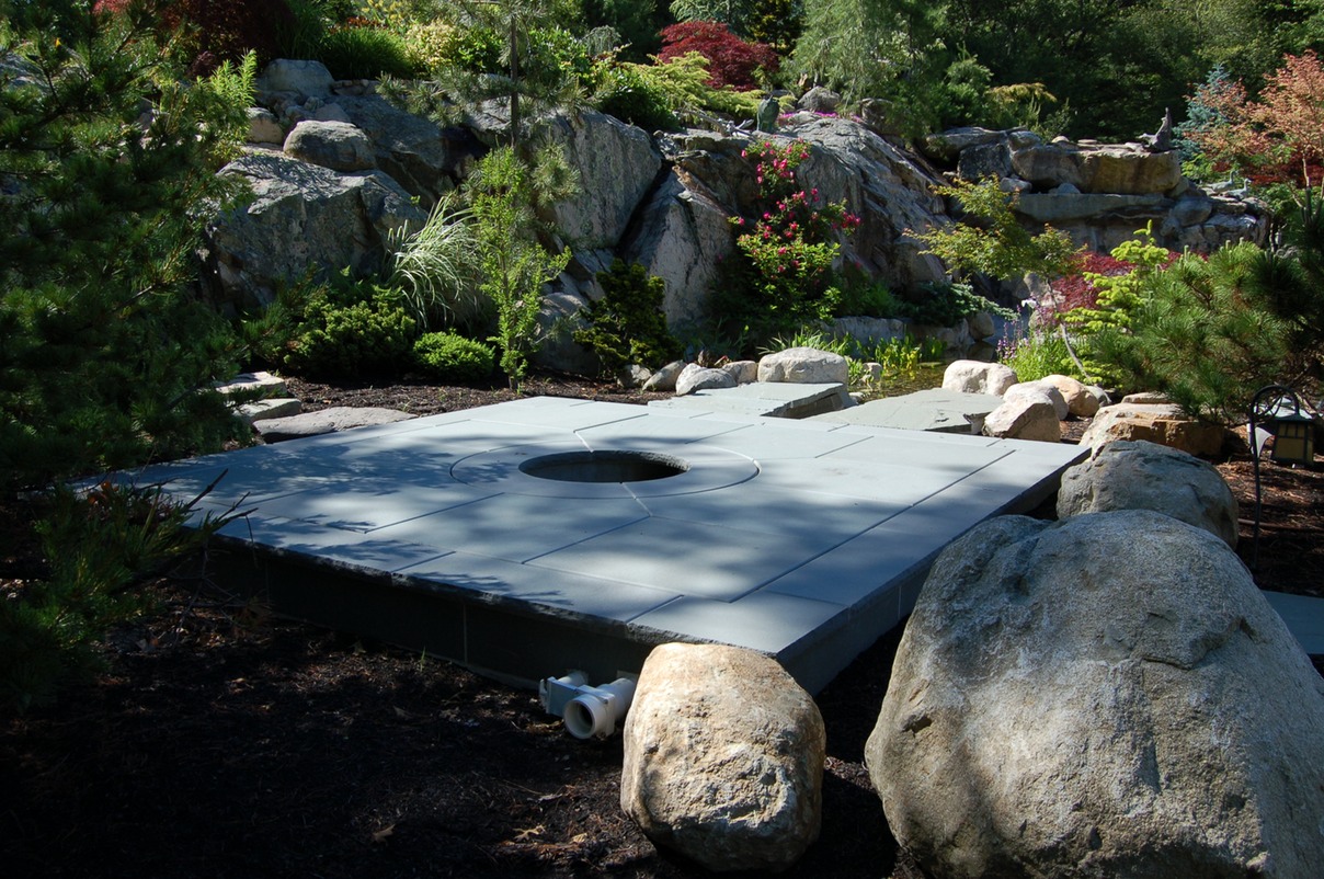 Custom pond filter system hidden under bluestone patio
